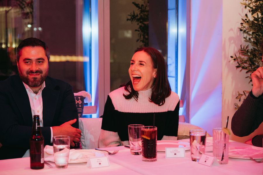 Two guests sharing a laugh at the dinner table.